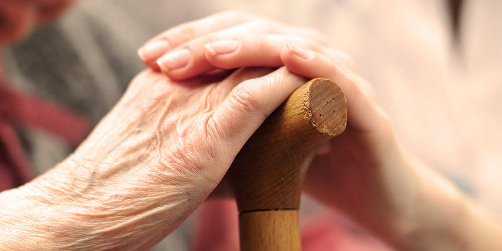 Elderly woman holding hands with younger woman Elderly woman holding hands with younger woman